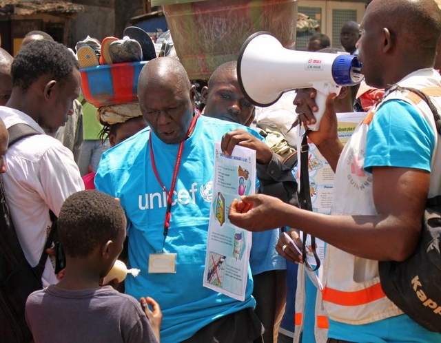 Health workers teach people about the Ebola virus and how to prevent infection in Conakry, Guinea, in March. / Youssouf Bah/Associated Press