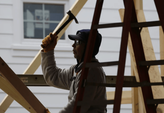 Silhouette of a construction working wielding a hammer